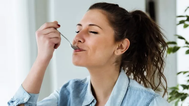 beautiful-young-woman-eating-yogurt-at-home-picture-id639933204