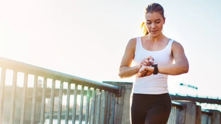 jogging-woman-checks-smart-watch-picture-id524232401