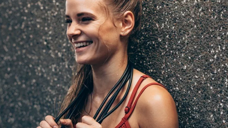 fitness-woman-leaning-to-a-wall-with-skipping-ropes-picture-id967681454