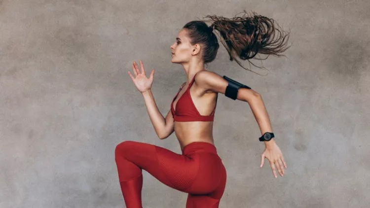 sportswoman-jumping-and-stretching-picture-id963115364