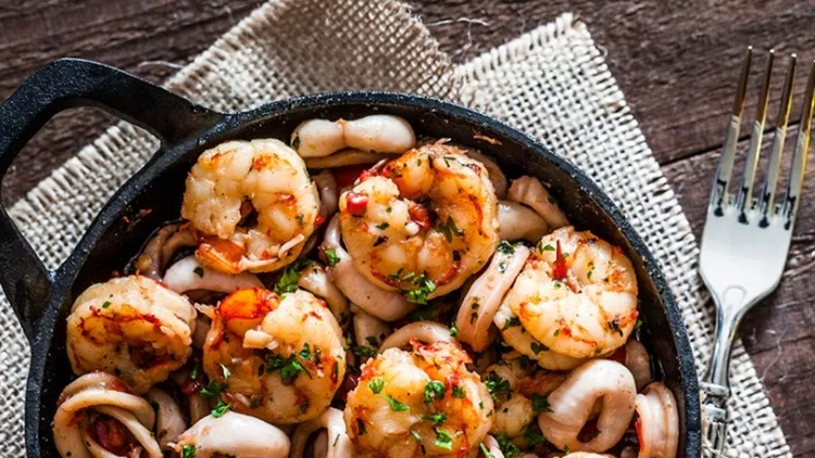 shrimps-and-calamari-rings-cooked-on-iron-cast-pan-picture-id863505818