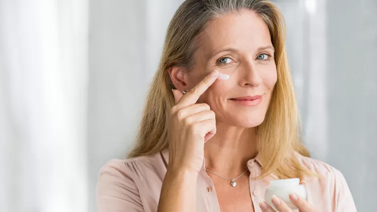 Woman applying anti aging lotion on face