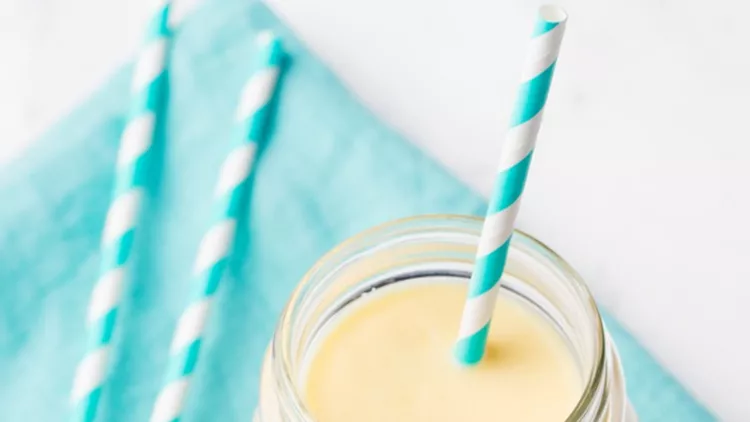 mango-coconut-yogurt-smoothie-in-glass-jar-on-blue-napkin-picture-id514167474