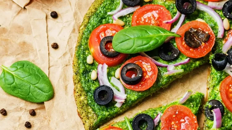 vegan-broccoli-zucchini-pizza-crust-with-spinach-pesto-tomatoes-onion-picture-id1151026703