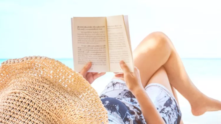 woman-reading-a-book-on-the-beach-in-free-time-summer-holiday-picture-id942466852