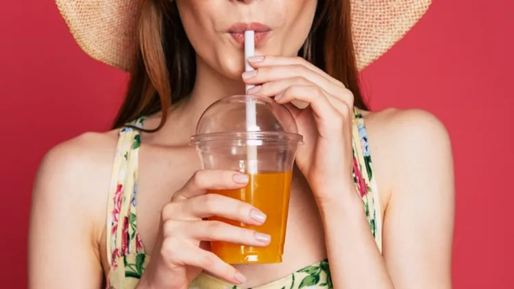 happy-woman-with-juice-in-summer-hat-picture-id1071692126