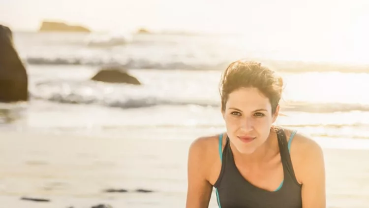 determined-woman-doing-sun-salutation-at-beach-picture-id538335728