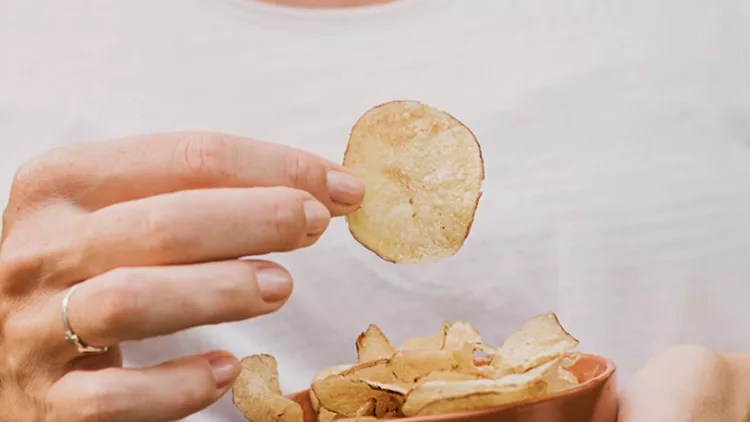 woman-eating-chips-snacks-close-up-of-hands-picture-id1011404208
