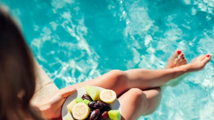woman-in-bikini-eating-fruits-and-relaxing-in-swimming-pool-all-picture-id1136451633