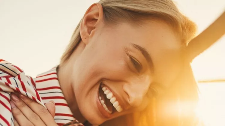 young-woman-laughing-against-of-sunset-background-picture-id1033250512