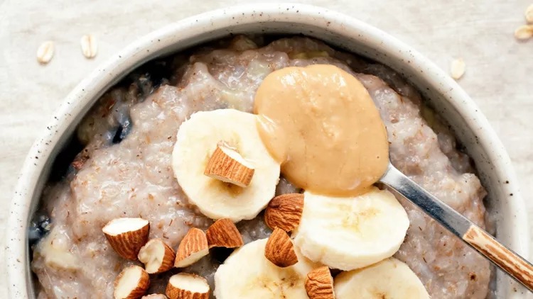 bowl-of-oatmeal-porridge-with-banana-and-peanut-butter-picture-id1130465301