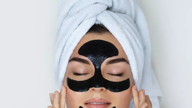young-and-beautiful-woman-with-black-peeloff-mask-on-her-face-picture-id1075661498