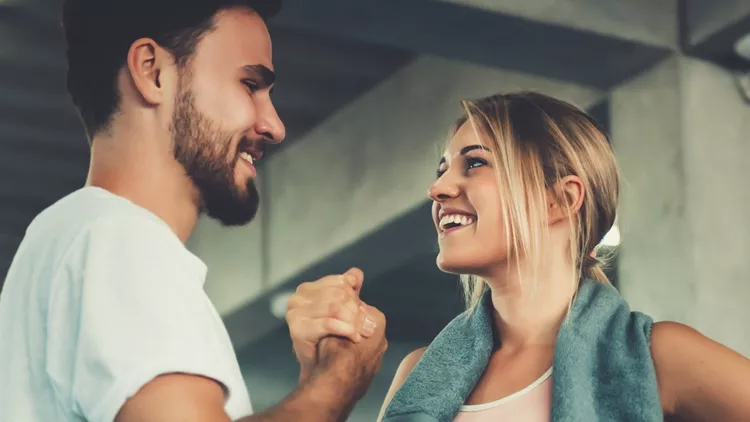 attractive-young-couple-handshaking-after-workout-in-fitness-gym-of-picture-id1094834888