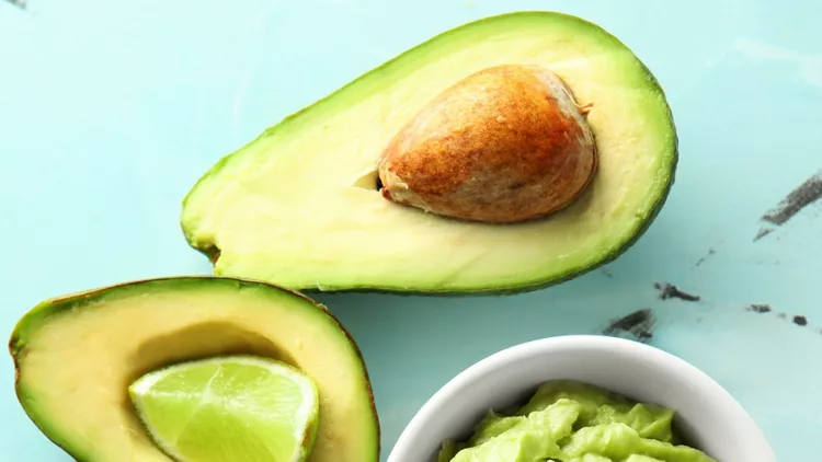 bowl-with-tasty-guacamole-and-ripe-avocado-on-table-picture-id1133778050