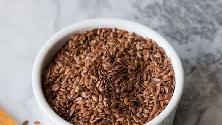 flax-seeds-in-ramekin-on-marble-board-picture-id964321988