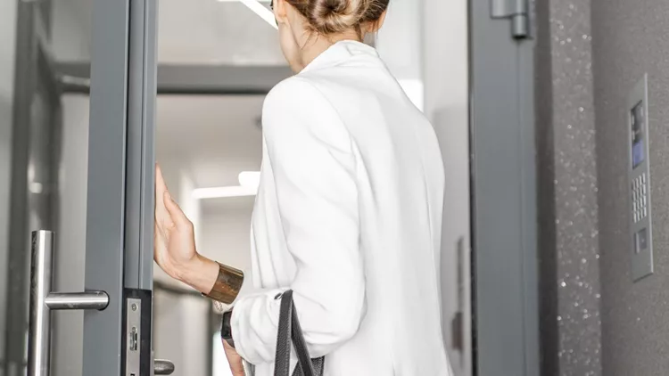 woman-entering-residential-building-picture-id1065781792