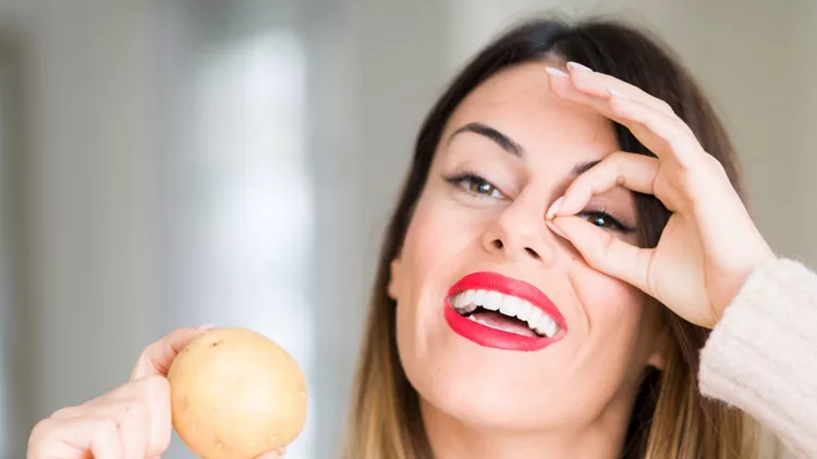 young-beautiful-woman-holding-fresh-potato-at-home-with-happy-face-picture-id1167526638