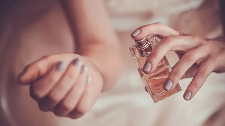 woman applying perfume on her wrist
