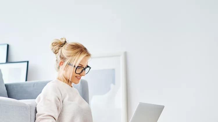 female-student-sitting-on-floor-of-her-apartment-with-laptop-and-picture-id1098364450
