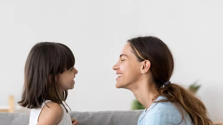 mother-spend-time-with-little-daughter-talking-sitting-on-couch-picture-id1070262182