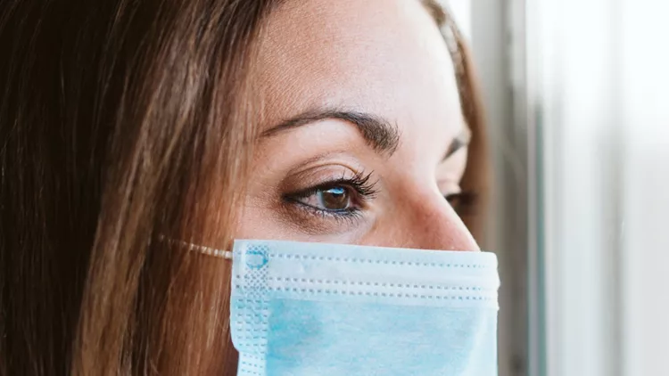 portrait-by-the-window-of-doctor-woman-wearing-protective-mask-and-picture-id1211938018