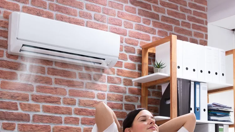 businesswoman-enjoying-the-cooling-of-air-conditioner-picture-id1125366045