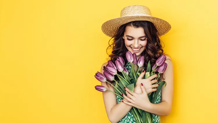 Lovely woman with purple tulips bunch