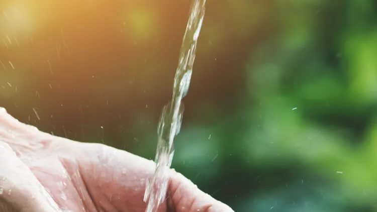 closeup-water-flow-to-hand-of-women-for-nature-concept-on-the-garden-picture-id1154091174