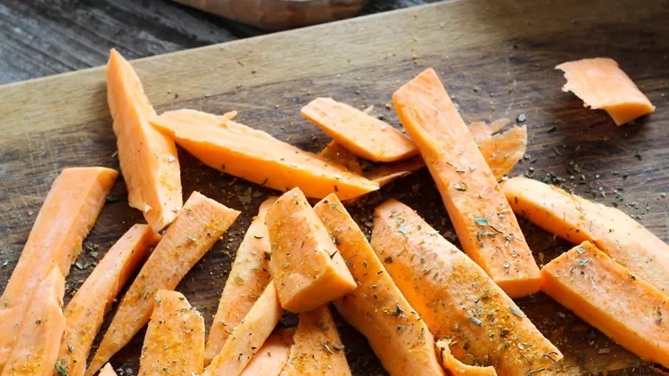 fresh-cut-slices-of-sweet-potatoes-with-herbs-picture-id519711386