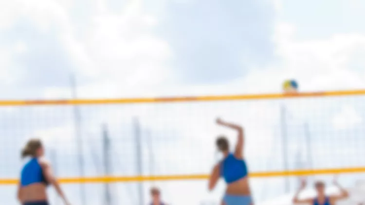 beach-volleyball-with-closeup-of-ball-in-foreground-picture-id95464537