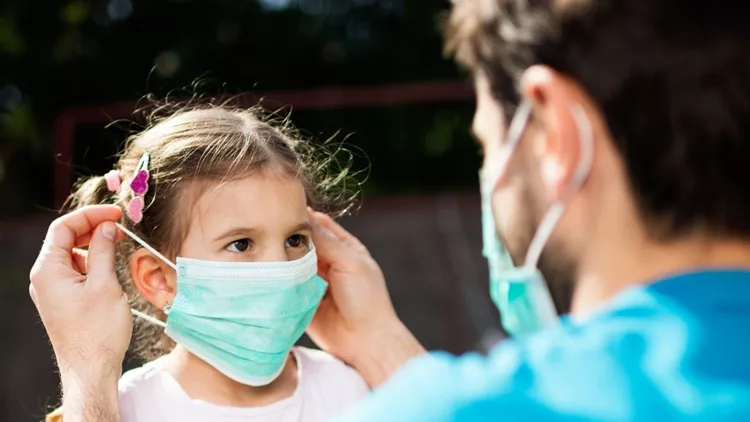 single-father-applying-pollution-mask-to-his-daughter-picture-id1214220442