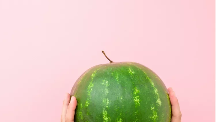 young-woman-hands-holding-one-green-watermelon-on-light-pastel-pink-picture-id1165464544 (1)