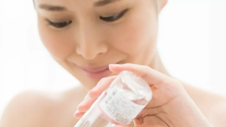 person-wearing-cosmetic-lotion-on-cotton-picture-id854885632