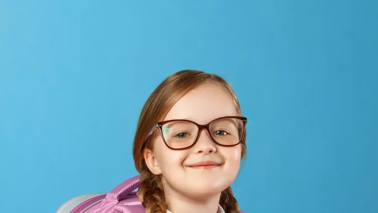 portrait-of-a-little-girl-schoolgirl-in-glasses-with-a-backpack-and-picture-id1159647816