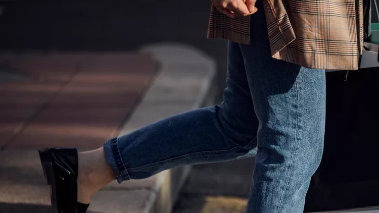 legs-of-an-unrecognizable-woman-in-jeans-walking-with-shopping-bags-picture-id1219772214