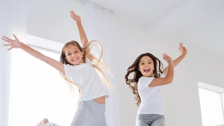 low-angle-photo-of-cheerful-kids-jumping-bed-have-free-time-raise-picture-id1163553655