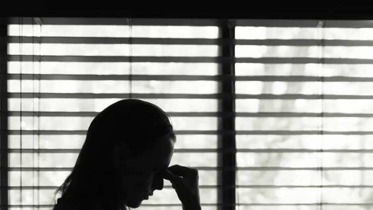 tired-woman-standing-next-to-bedroom-window-picture-id1181078647