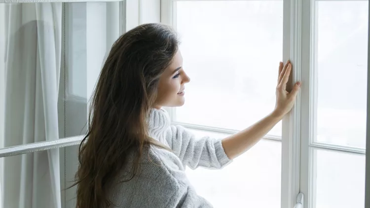 woman-in-warm-woolen-pullover-is-opening-window-picture-id998518486