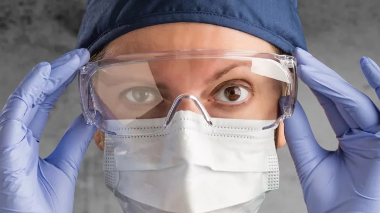 female-doctor-or-nurse-wearing-scrubs-and-protective-mask-and-goggles-picture-id1204503391