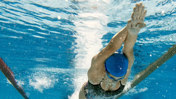 underwater-shot-of-young-women-diving-into-water-and-starting-the-picture-id1027864882