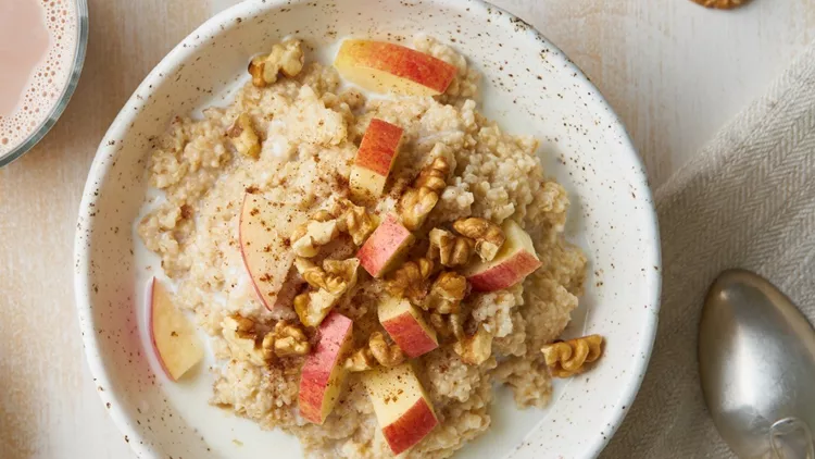 oatmeal-with-apple-nuts-honey-and-cup-of-chocolate-on-white-wooden-picture-id1152612386