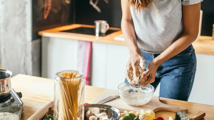 young-woman-preparing-pizza-picture-id1049042926