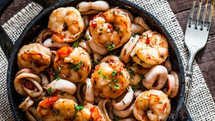 shrimps-and-calamari-rings-cooked-on-iron-cast-pan-picture-id863505818