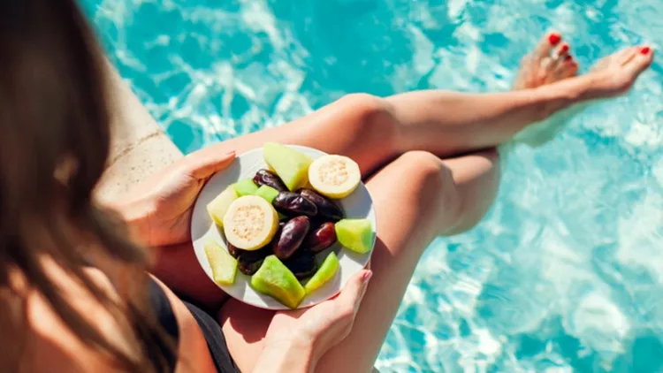 woman-in-bikini-eating-fruits-and-relaxing-in-swimming-pool-all-picture-id1136451633