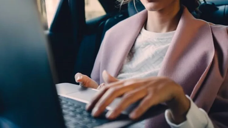 woman-using-a-laptop-in-a-car-picture-id629062202