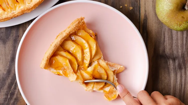 child-hand-eating-a-portion-of-apple-tart-picture-id1036675262