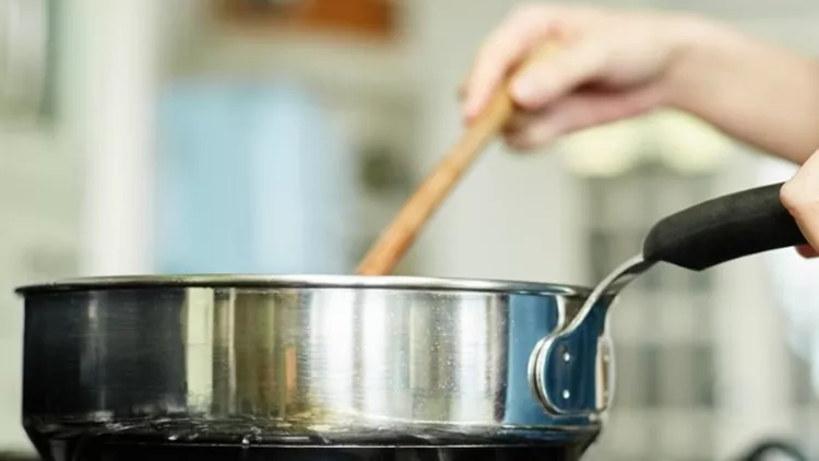 midsection-image-of-woman-cooking-food-in-pan-picture-id480132468