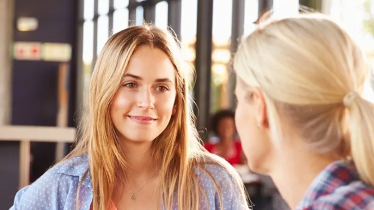 two-female-friends-talking-at-a-coffee-shop-picture-id478406876