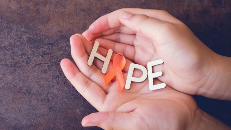 hands-holding-hope-with-orange-ribbons-on-toning-background-leukemia-picture-id650064168