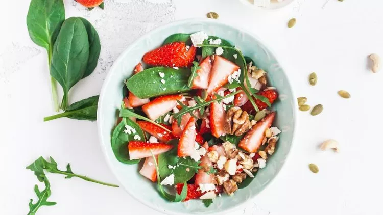 spinach-leaves-sliced-strawberries-nuts-feta-cheese-on-white-picture-id647765938